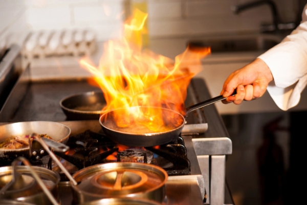 Chef cooking in kitchen stove powered by propane