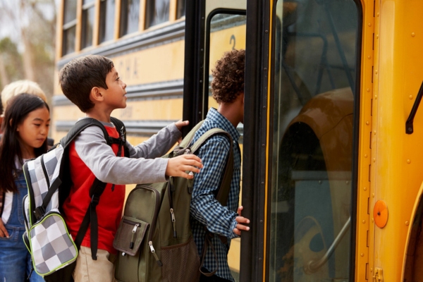 school kids climbing onto a school bus