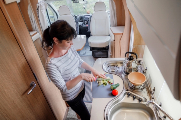 Woman cooking in her motorhome using propane powered stove